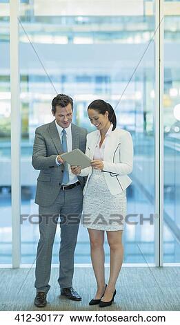 Stock Photo - Businessman and businesswoman using digital tablet in office. Fotosearch
