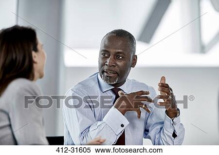 Businessman explaining to businesswoman in meeting View Large Photo Image Stock Photography - Businessman explaining to businesswoman in meeting. Fotosearch