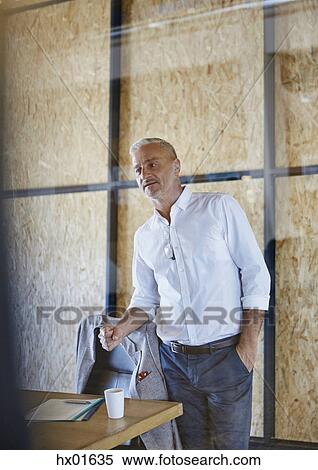 Stock Photography - Businessman gesturing with fist in conference room meeting. Fotosearch