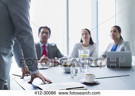 Stock Photograph - Businessman leading meeting in conference room. Fotosearch