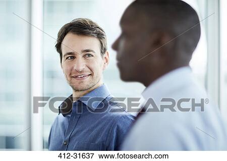 Stock Photo - Businessman listening to colleague. Fotosearch