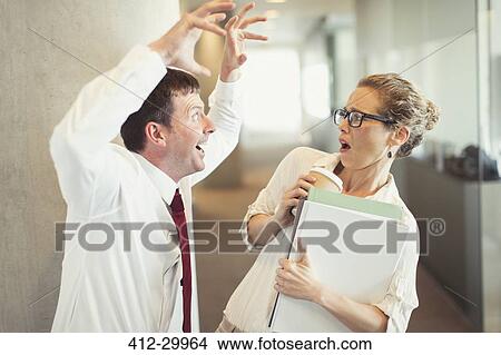 Businessman making snarling gesture at terrified businesswoman View Large Photo Image Picture - Businessman making snarling gesture at terrified businesswoman. Fotosearch