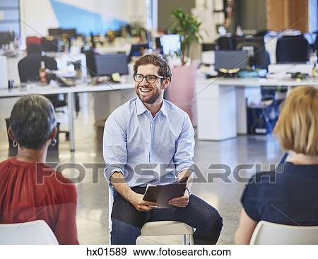 Businessman smiling in meeting View Large Photo Image Stock Photo - Businessman smiling in meeting. Fotosearch