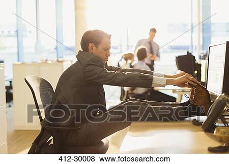 Businessman stretching feet on desk in office View Large Photo Image Stock Photo - Businessman stretching feet on desk in office. Fotosearch
