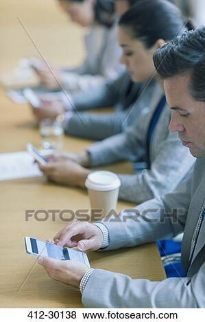 Businessman using cell phone in conference room View Large Photo Image Stock Photo - Businessman using cell phone in conference room. Fotosearch