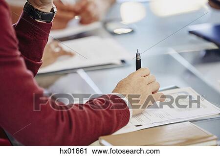 Businessman with paperwork in meeting View Large Photo Image Stock Image - Businessman with paperwork in meeting. Fotosearch