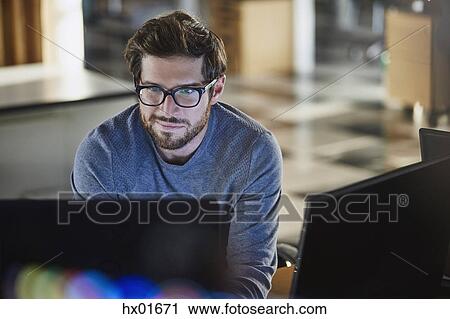 Businessman working at computer in office View Large Photo Image Stock Image - Businessman working at computer in office. Fotosearch