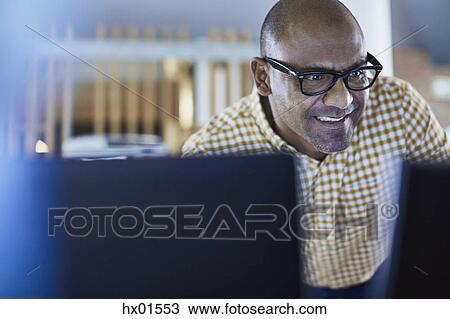 Stock Image - Businessman working at computer. Fotosearch