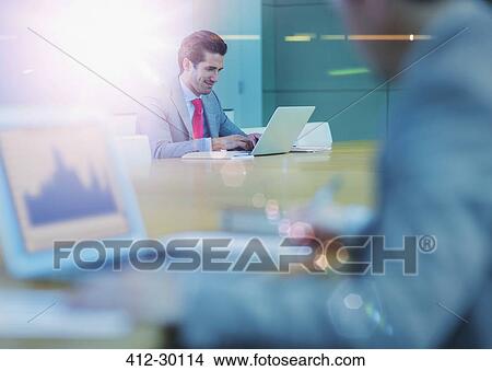 Picture - Businessman working at laptop in conference room. Fotosearch