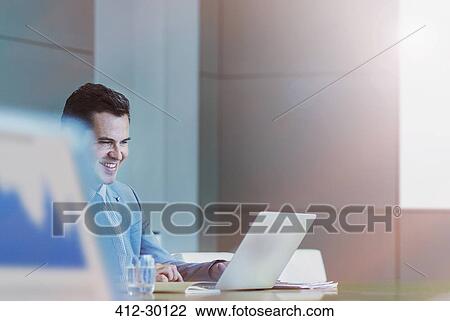 Businessman working at laptop in conference room View Large Photo Image Stock Image - Businessman working at laptop in conference room. Fotosearch