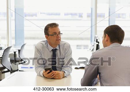 Businessmen talking in office View Large Photo Image Stock Image - Businessmen talking in office. Fotosearch