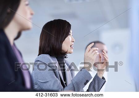Businesswoman gesturing and explaining in meeting View Large Photo Image Stock Image - Businesswoman gesturing and explaining in meeting. Fotosearch