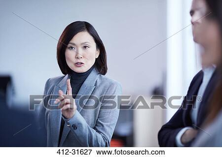 Businesswoman gesturing and explaining in meeting View Large Photo Image Stock Photo - Businesswoman gesturing and explaining in meeting. Fotosearch
