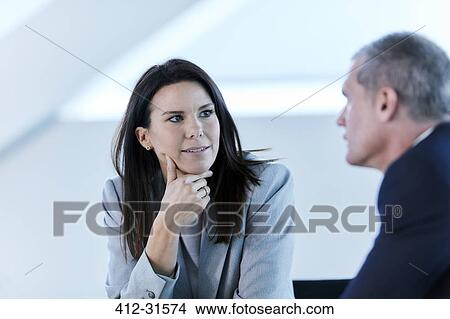 Picture - Businesswoman listening to businessman in meeting. Fotosearch