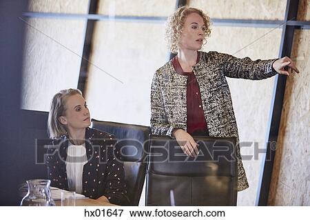 Businesswoman pointing in conference room meeting View Large Photo Image Stock Photo - Businesswoman pointing in conference room meeting. Fotosearch