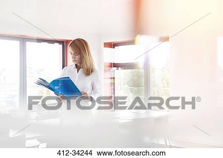Businesswoman reviewing paperwork in conference room View Large Photo Image Picture - Businesswoman reviewing paperwork in conference room. Fotosearch