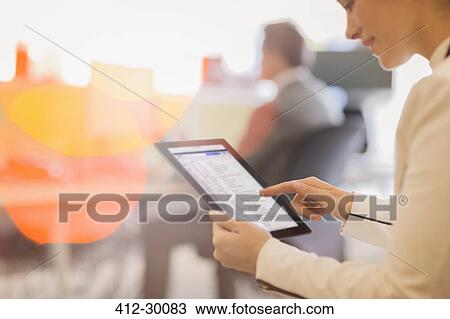 Stock Image - Businesswoman using digital tablet in office. Fotosearch