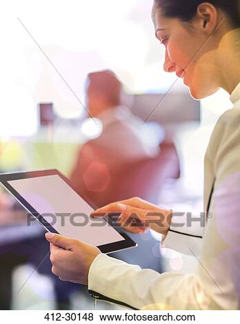 Stock Photo - Businesswoman using digital tablet in office. Fotosearch