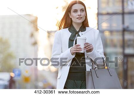 Businesswoman walking with coffee in city View Large Photo Image Stock Image - Businesswoman walking with coffee in city. Fotosearch