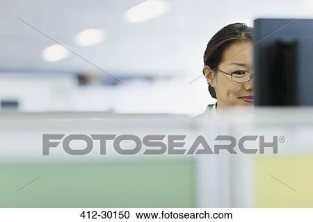Stock Image - Businesswoman working at computer in office. Fotosearch