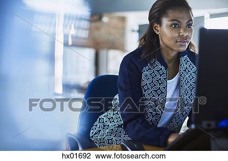 Stock Image - Businesswoman working at laptop in office. Fotosearch