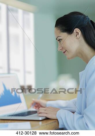 Businesswoman working at laptop in conference room View Large Photo Image Stock Photo - Businesswoman working at laptop in conference room. Fotosearch
