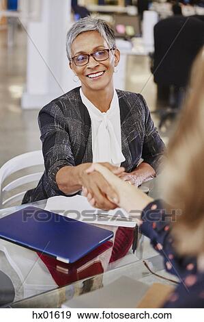 Businesswomen handshaking in meeting View Large Photo Image Stock Photo - Businesswomen handshaking in meeting. Fotosearch