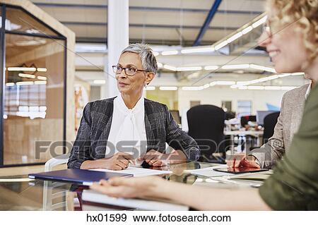 Businesswomen listening in conference room View Large Photo Image Stock Photo - Businesswomen listening in conference room. Fotosearch