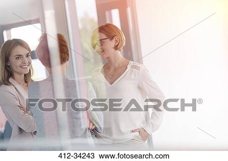 Businesswomen talking in office View Large Photo Image Stock Image - Businesswomen talking in office. Fotosearch