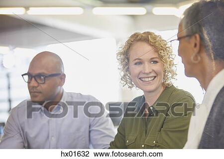 Stock Image - Businesswomen talking in office. Fotosearch