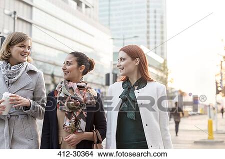Businesswomen walking with coffee in city View Large Photo Image Picture - Businesswomen walking with coffee in city. Fotosearch