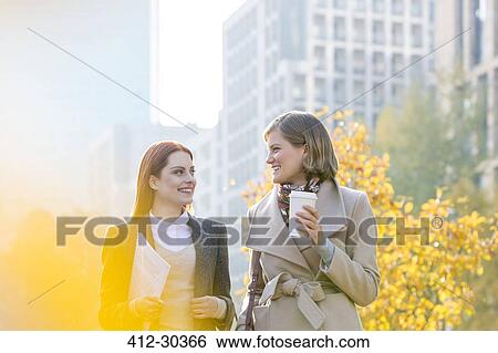 Businesswomen walking with coffee in city View Large Photo Image Stock Photograph - Businesswomen walking with coffee in city. Fotosearch