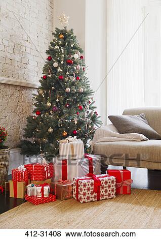 Stock Photo - Christmas tree and gifts in living room. Fotosearch