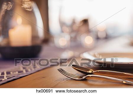Close up illuminated candle and placesetting on dining table View Large Photo Image Stock Image - Close up illuminated candle and placesetting on dining table. Fotosearch