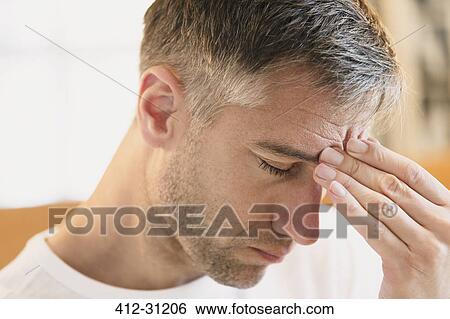 Close up of man with headache touching forehead View Large Photo Image Stock Photograph - Close up of man with headache touching forehead. Fotosearch