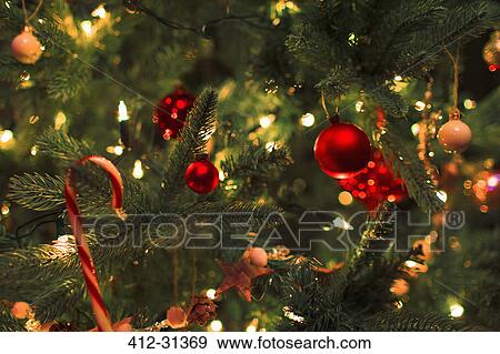 Stock Photo - Close up ornaments and string lights on Christmas tree. Fotosearch