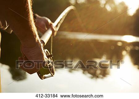 Close up senior man fly fishing at sunny lake View Large Photo Image Picture - Close up senior man fly fishing at sunny lake. Fotosearch