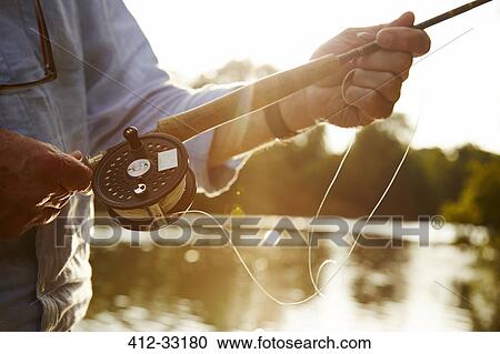 Close up senior man fly fishing at sunny river View Large Photo Image Stock Image - Close up senior man fly fishing at sunny river. Fotosearch