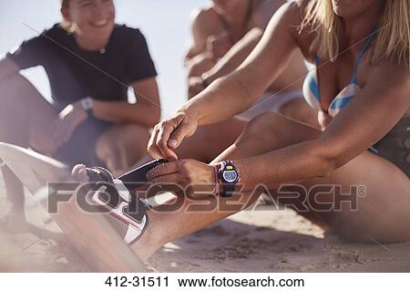 Close up woman fastening kiteboard to feet on beach View Large Photo Image Stock Image - Close up woman fastening kiteboard to feet on beach. Fotosearch