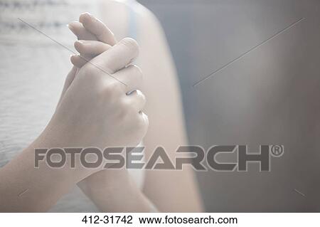 Stock Image - Close up woman rubbing hands. Fotosearch