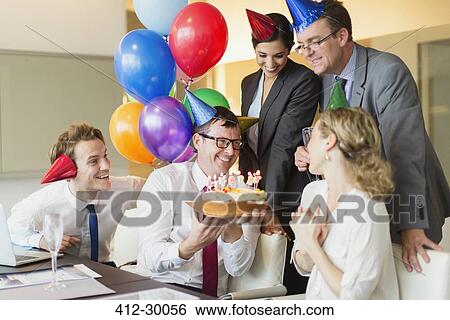 Colleagues presenting businesswoman with birthday cake in conference room View Large Photo Image Stock Photograph - Colleagues presenting businesswoman with birthday cake in conference room. Fotosearch