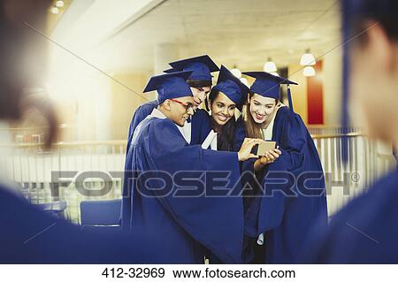 College graduates in cap and gown taking selfie View Large Photo Image Stock Photo - College graduates in cap and gown taking selfie. Fotosearch