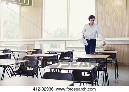 College professor collecting tests on desks in classroom View Large Photo Image Stock Photograph - College professor collecting tests on desks in classroom. Fotosearch