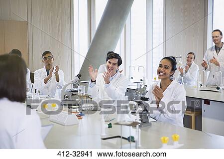 Stock Image - College students clapping for classmate in science laboratory classroom. Fotosearch