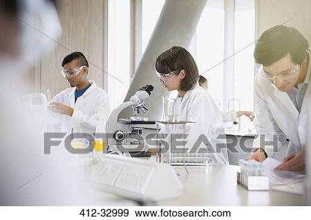 Stock Photo - College students conducting scientific experiment in science laboratory classroom. Fotosearch