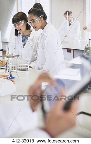 Stock Photo - College students conducting scientific experiment in science laboratory classroom. Fotosearch