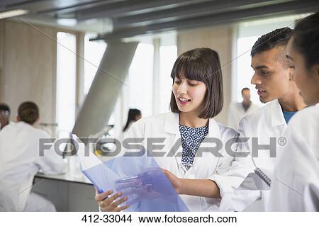 College students discussing notes in science laboratory classroom View Large Photo Image Picture - College students discussing notes in science laboratory classroom. Fotosearch