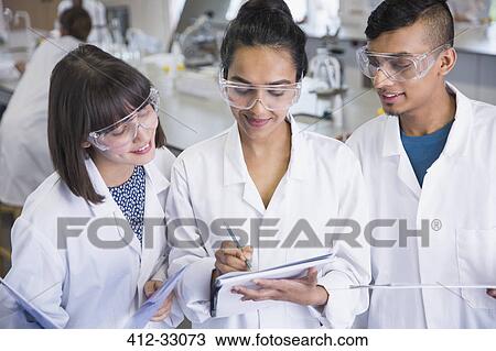 College students in lab coats discussing notes in science laboratory classroom View Large Photo Image Stock Image - College students in lab coats discussing notes in science laboratory classroom. Fotosearch