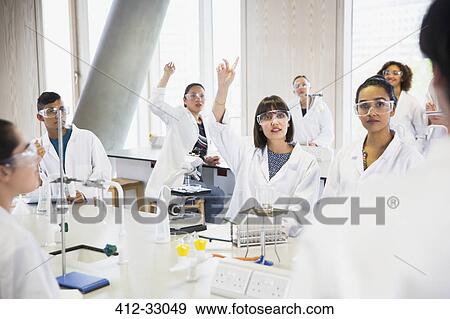 Stock Photo - College students raising hands in science laboratory classroom. Fotosearch