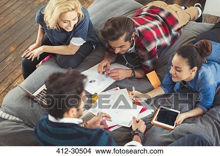 Picture - College students studying on bed. Fotosearch